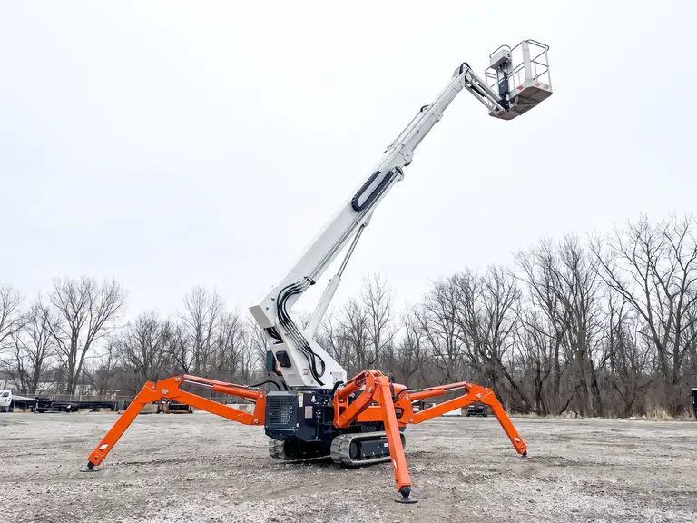 Tracked spider boom lift with its outriggers deployed and the platform raised